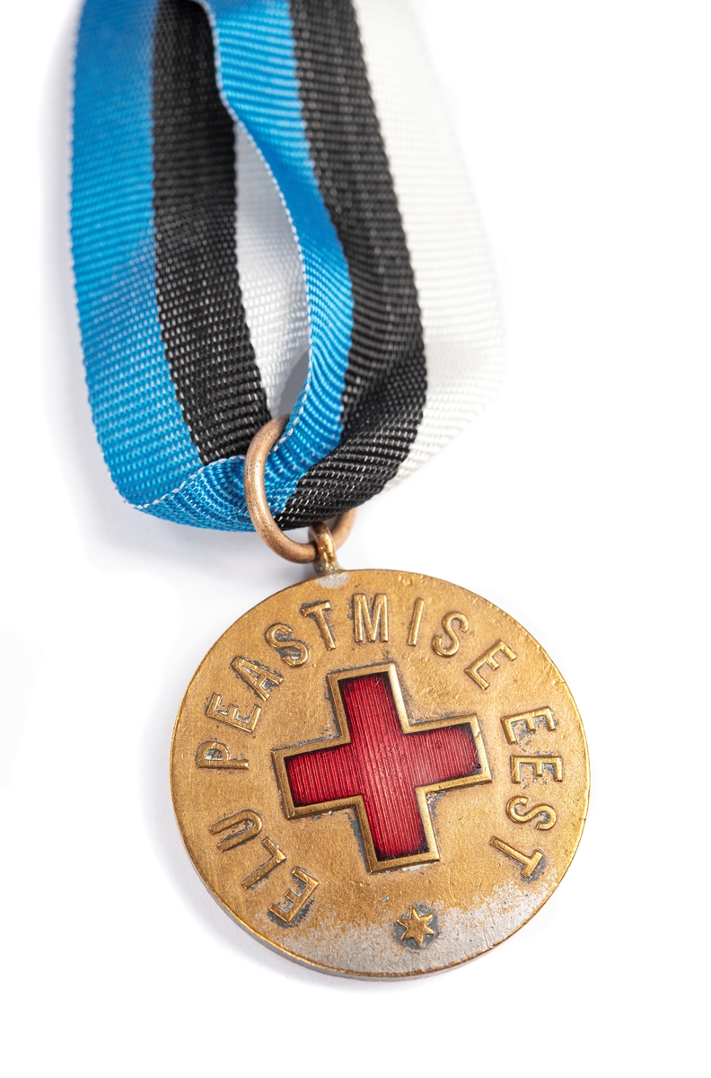Medalj med estniska färger. Medtogs på flykt från Nargö, Estland till Sverige år 1943. 
