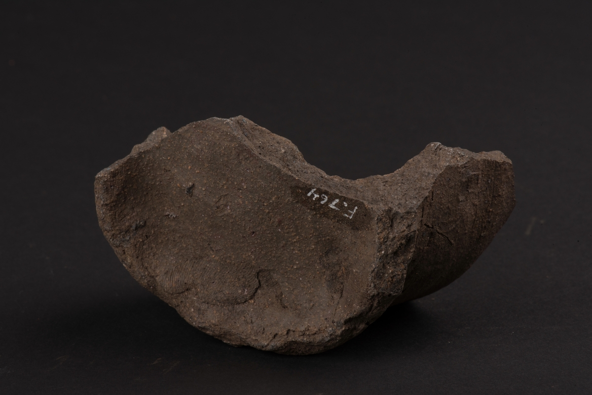 Fragment av lerkärl från medeltiden.
Består av botten, något utkragat, och del av sidan.