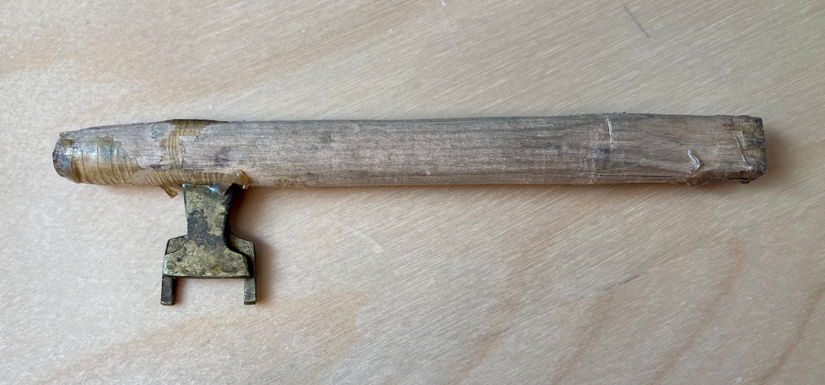 Hjemmelaget nøkkel laget av en trepinne og to tilskårede metallbiter.