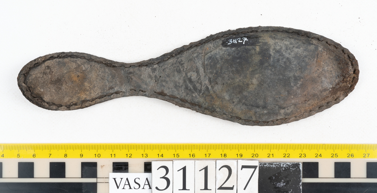 Delar och fragment från sko; tre sulor, en holtrand, en klacklapp, en klacklapp eller ett inlägg samt ett 40-tal delar och mindre fragment från skoöverdel och skobotten.
Sula fyndnummer 31127 har kvarsittande tråd. På sulans ovansida finns intryck av bindtråden.  Sula fyndnummer 31127:1 har kvarsittande träpligg och tråd. I tåpartiet finns en laglapp. Sulans hälparti är avskuret, eventuellt avbrutet.  Sula fyndnummer 31127:2 har ett fragmentariskt hälparti. På sulans ovansida finns intryck av bindtråd. Holtrand fyndnummer 31127:3 har kvarsittande tråd. På klacklapp fyndnummer 31127:4 finns hål efter träpligg. På klacklapp, eventuellt inlägg, fyndnummer 31127:5 finns kvarsittande tråd.