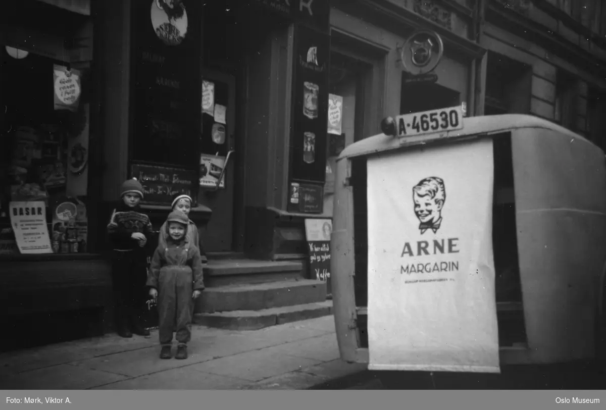 bygård, O. Mørk kolonialforretning, inngangsparti, utstillingevinduer, barn, bil, reklame for Arne margarin