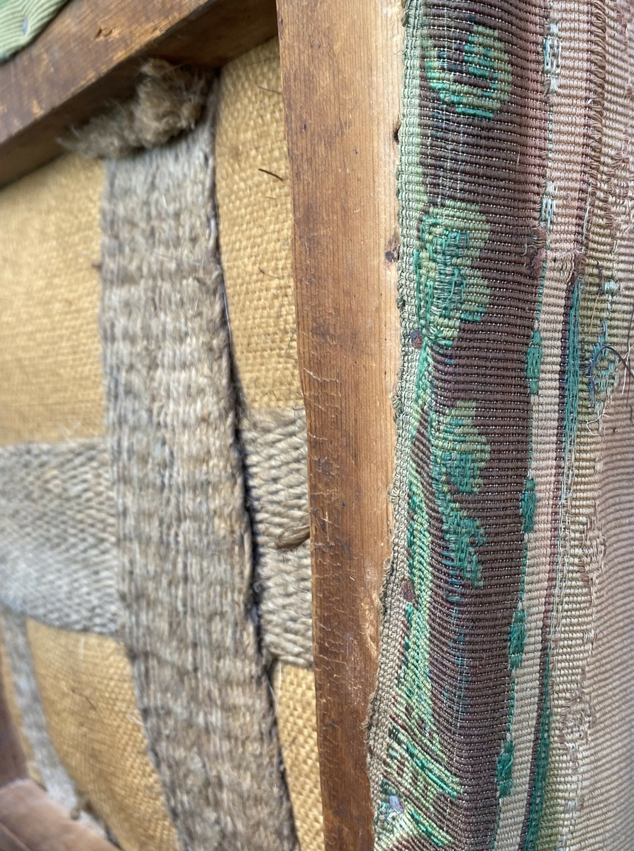 Stolsete med tekstiltrekk er ødelagt. Trekt med mønstret tekstil, som tidligere har vært grønt. Spor av farge og mønster på undersiden av stolputa. 