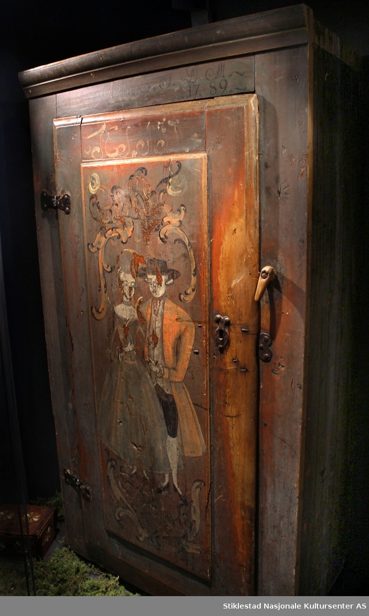 Matskapet dekorert med rosemaling og figurmaling av «rokokkomaleren» Ole Haldosen Berg (1747-1828). 
Gesimsen øverst på sideveggene er fjernet, og spikrene på hengslene er skiftet ut, ellers er skapet intakt med originale beslag (festet på nytt?). Motivet på døra viser et par i finstasen med rokokkoranker rundt. Øverst på døra står bokstavene TES.MJD. Over døra står årstallet 1755, men dette er overskrevet med bokstavene N.O.S.M..E.T.D.M og årstallet 1789. Vi antar at S og D i begge tekstene står for sønn og datter, og at dette er initialene til eierparene, som har skiftet i 1789.
Skapet har en del slitasje på høyre side av døra, ved låsen, etter åpning og lukking av skapet. Etter høyden på disse slitesporene å dømme, har også de minste vært inne i matskapet en del i løpet av årene. Helt nederst vises også hull etter mus som har gnagd seg inn på jakt etter mat. Baksiden av skapet er grovt tilvirket, her vises tydelige spor etter bearbeiding med både øks og pjål/skjøve. Målene på skapet er 170x45x92 cm. Innvendig har skapet tre hylle, mangler nøkkel