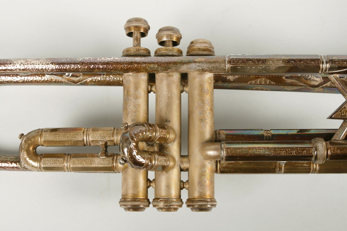 Instrument i metall med tre ventiler.
