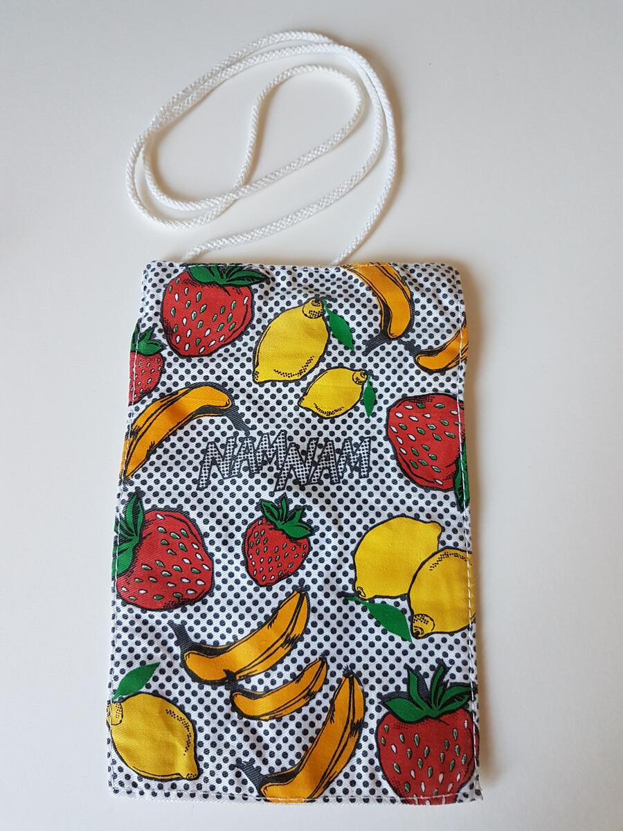 Tågluffarväska i färggrant tyg med fruktmotiv, jordgubbar, bananer och citroner. Väskan producerades tillsammans av RFSU, SJ och AIDS-delegationen