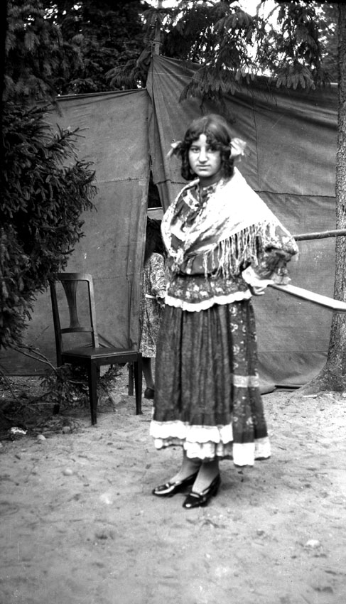 En romsk kvinna utanför ett tält.