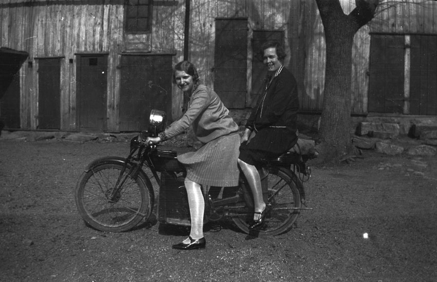 Två kvinnor sitter på en motorcykel.