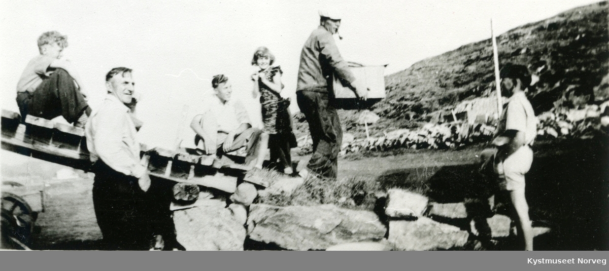 Ingvar Stamnes med pipe og kasse ned låvebrua sammen med ukjente på Stamnes i Flatanger