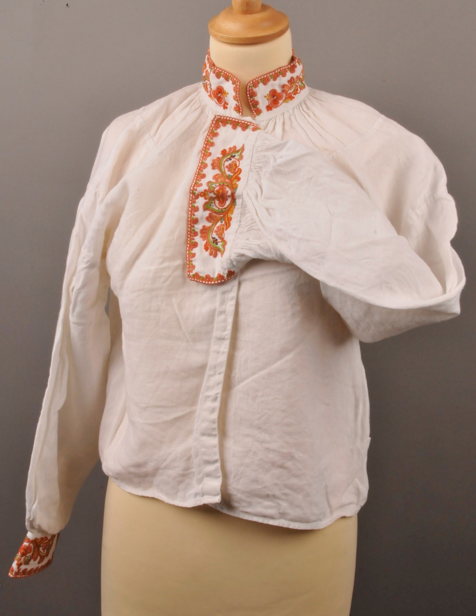 Kvit skjorte med rosesaum, aksleklutar, armelaskar, Rynka ved armliner og halsline.