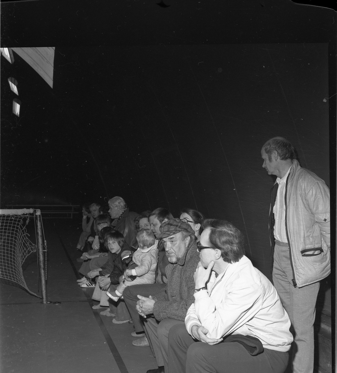 Publik i samband med tennisturnering i Barracudahallen i Gränna. En ljushårig längre man i publiken är Lennart Blom. Med keps är Olle Hermansson och stående är Ingvar Fransson.