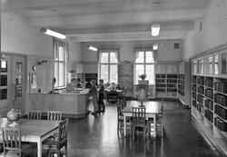 Barneavdelingen på Rjukan bibliotek. Barn står ved disken og