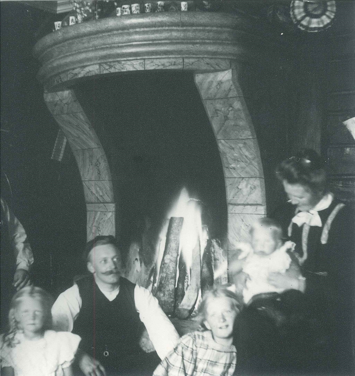 Familien Rydgren foran peisen på Mosjøhytta i Nordmarka.
Fra venstre: Eivor (Eia,) uidentifisert mann, Wilfried (Willis), Wilhelm Fredrik (Lillegutt) og fru Nicoline Rydgren.