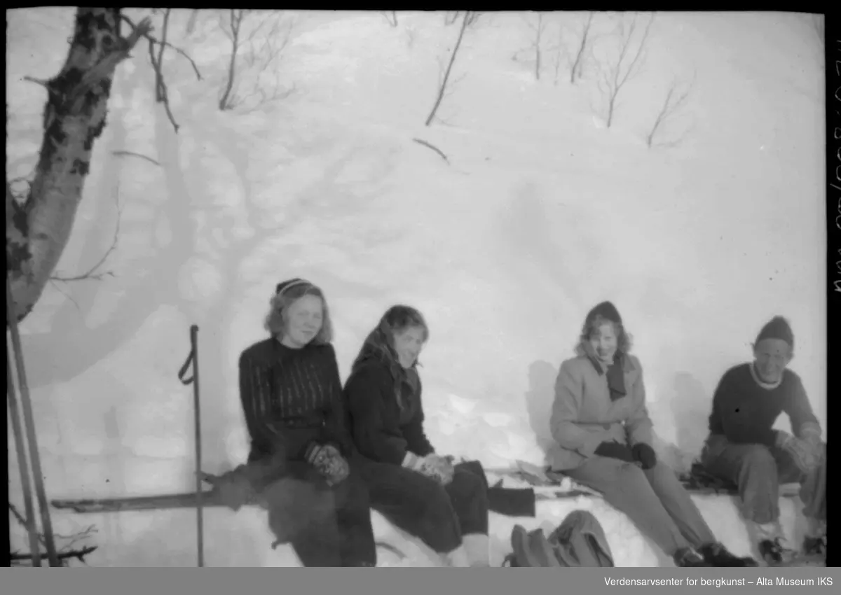 3kvinner og mann tar seg en pause på skitur.