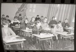 Fotografi av en skoleklasse med ni jenter og sju gutter kled