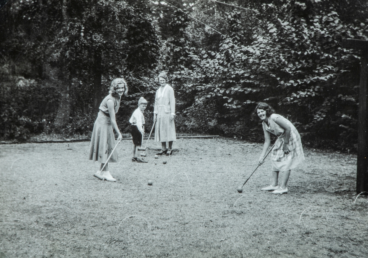 Krokketspill i hagen på Ottestad nordre på begynnelsen av 1930-tallet. Til venstre: Andrea Glærum, født Gjestvang (1914-1993), Even Ringnes (1924-2004), hans mor, Agnes Wollebæk, født  Såstad (1900-1981), og Else Weltzin, født Gjestvang (1919-?) Krokket.