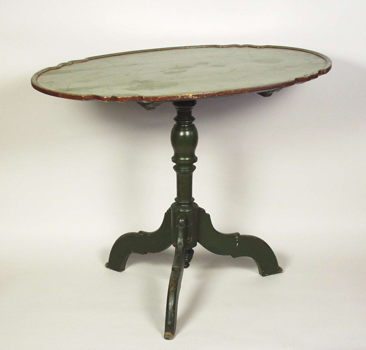 Vippebord med oval bordplate og tredelt fot. Foten er dreid. Bordet er grønnmalt. Bordplaten er ådret.