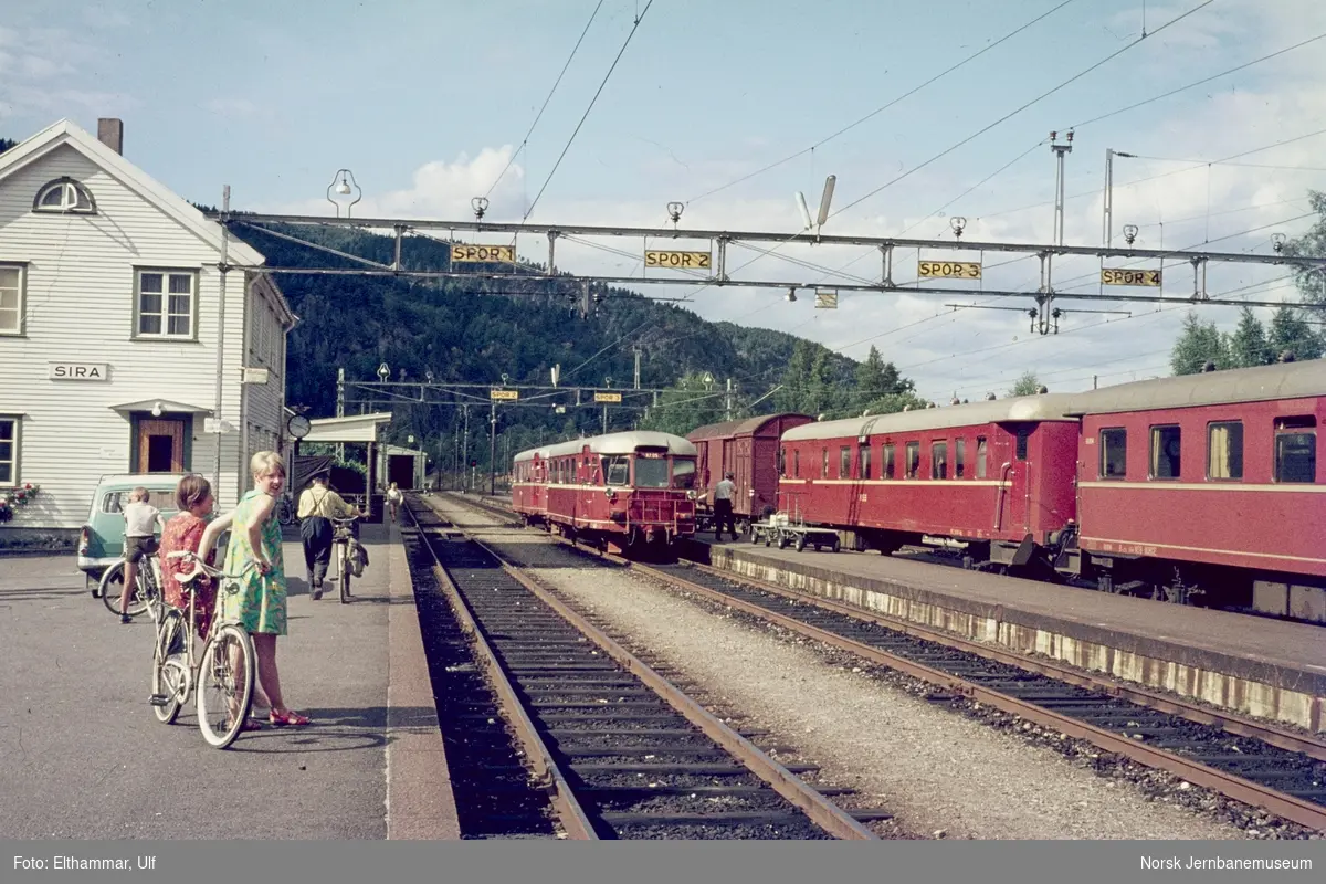 Sira stasjon med persontog til Flekkefjord (t.v.) med to dieselmotorvogner type Bmdo 87, med 87 05 nærmest, og fra Stavanger til Kristiansand med elektrisk motorvognsett type 68A