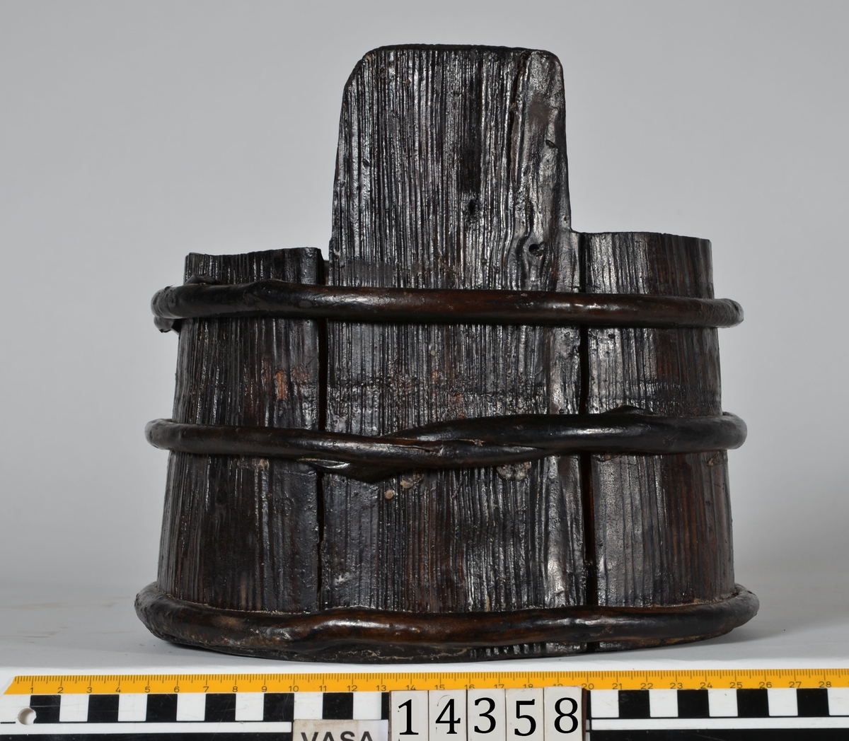 En laggad bytta med lock. 
14358:1 Byttan består av sex laggstavar, en bottenplatta och tre vidjeband. Två av laggstavarna, de så kallade ståndarna, är längre än de övriga laggstavarna. Den ena ståndaren är försedd med ett fyrkantigt urtag. Urtaget har fungerat för fastsättningen av locket.
14358:2 Locket består av en run platta och är försett med ett handtag. På plattan finns två urrtag för byttans ståndare. I det ena urtaget finns en tapp som ska passa i det ovan nämnda fyrkantiga urtaget.