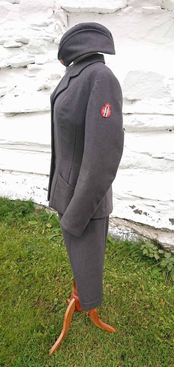 Uniform for medlem av Norges Lotteforbund. Den består av jakke, skjørt, lue og skjorte.