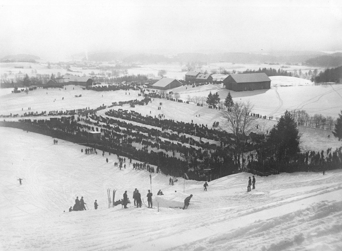 Husebybakken, utsikt over folkemengden og området rundt hoppbakken. Fotografert 1923.