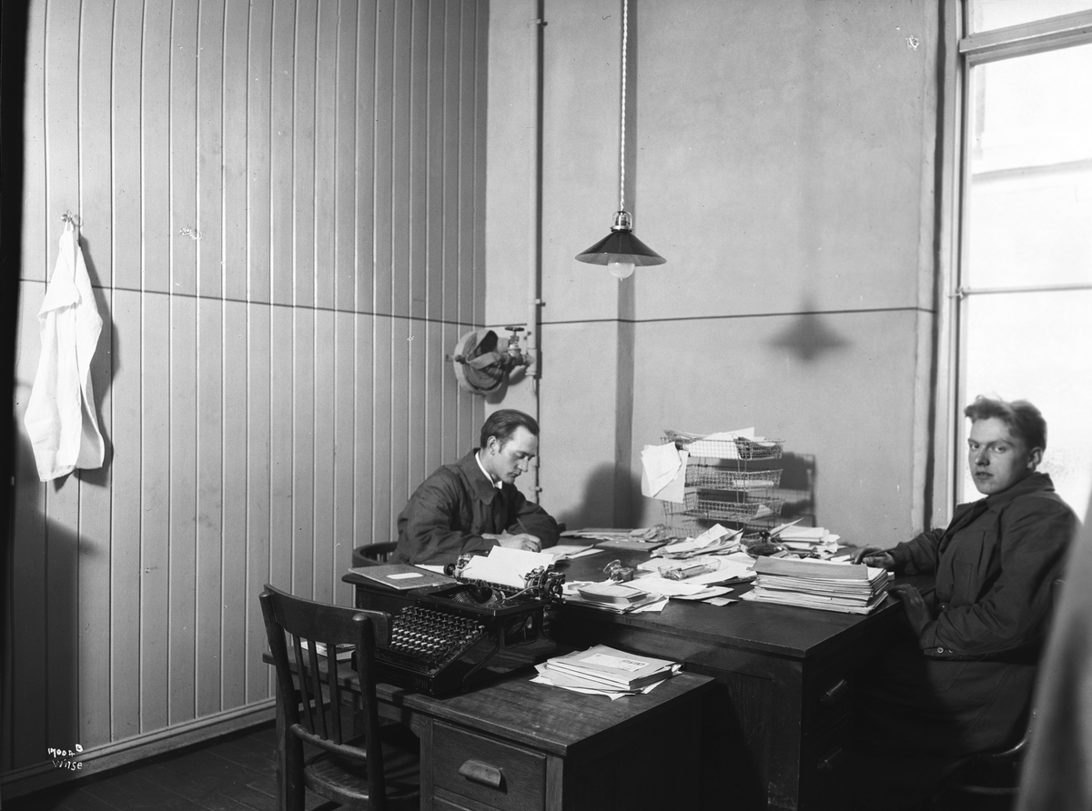 To kontorister sitter ved skrivebord, Sørensen og Balchen A/S. Fotografert 1923.