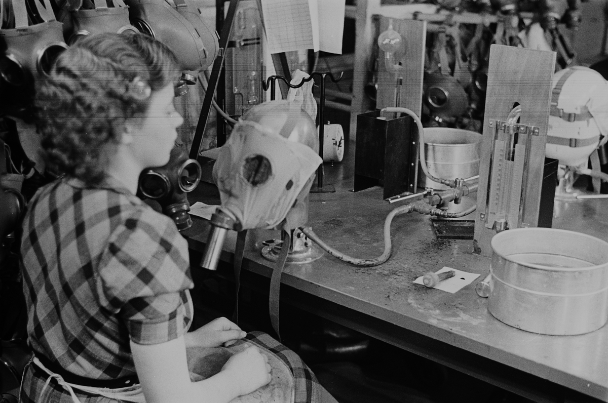 Kvinnelig arbeider ved gassmaskeproduksjonen ved Askim Gummivarefabrikk. Fotografert 1940.