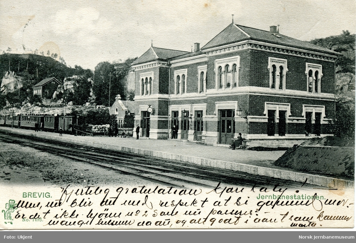 Brevik stasjon, med persontog til venstre. En vognmann med hest og vogn på plattformen