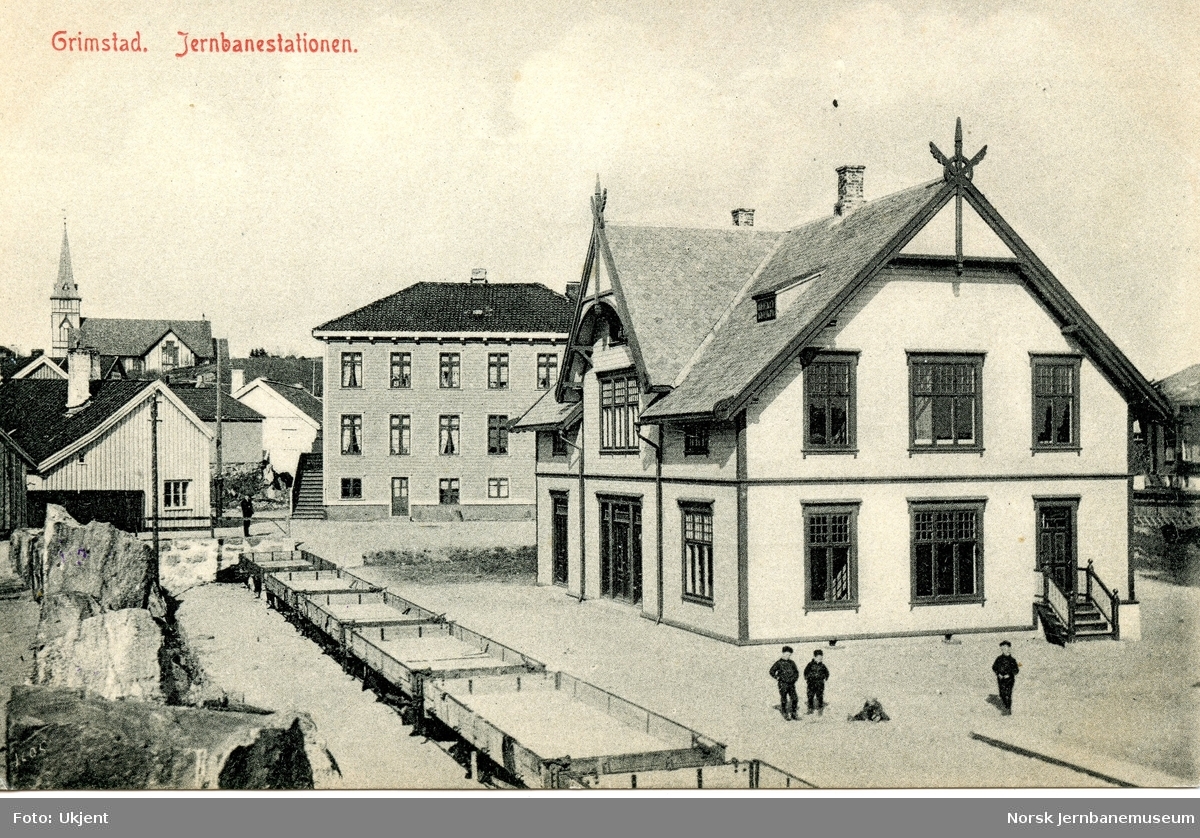 Grimstad stasjon med grusvogner i spor 1, trolig kort tid før åpningen i 1907