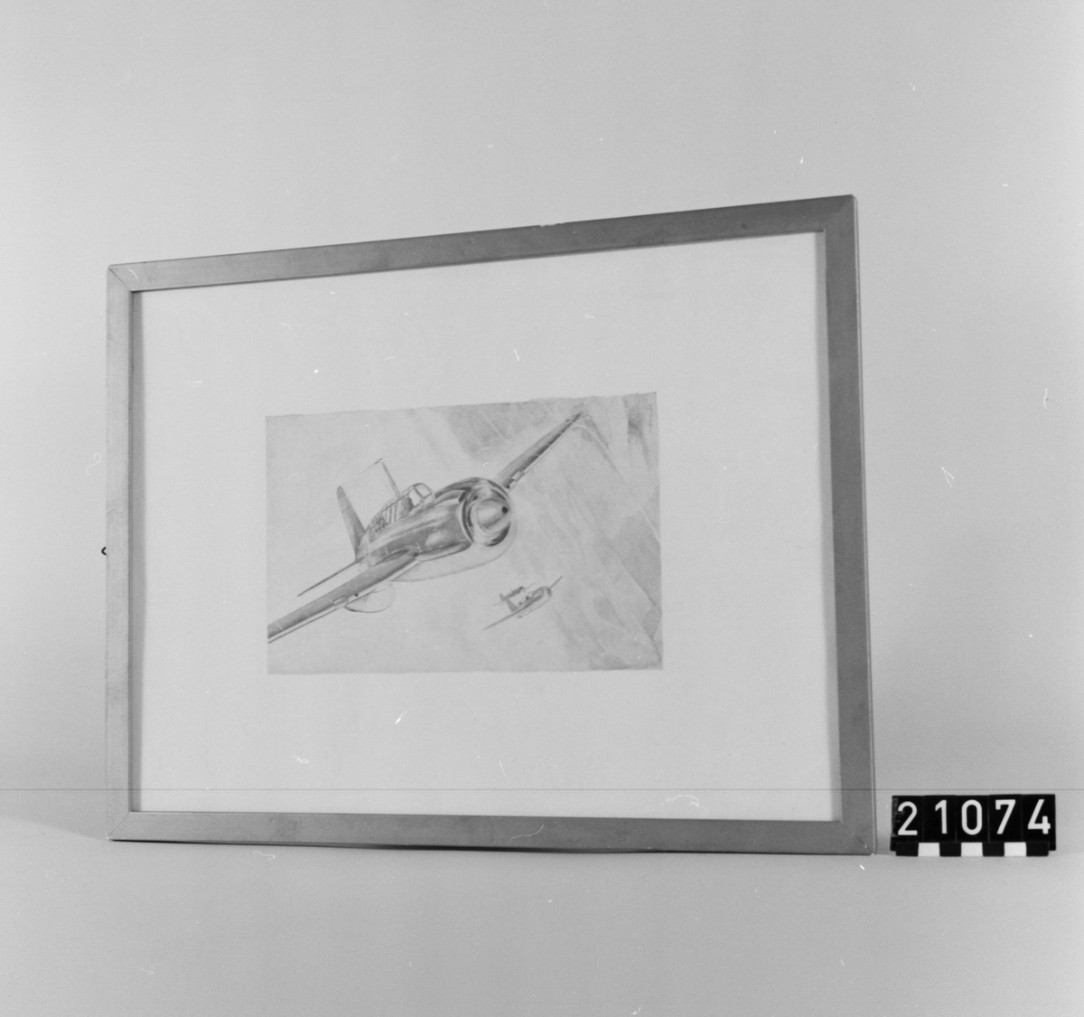 Motiv av flygplan under flygning, i bakgrunden ytterligare två plan. I glas och ram.