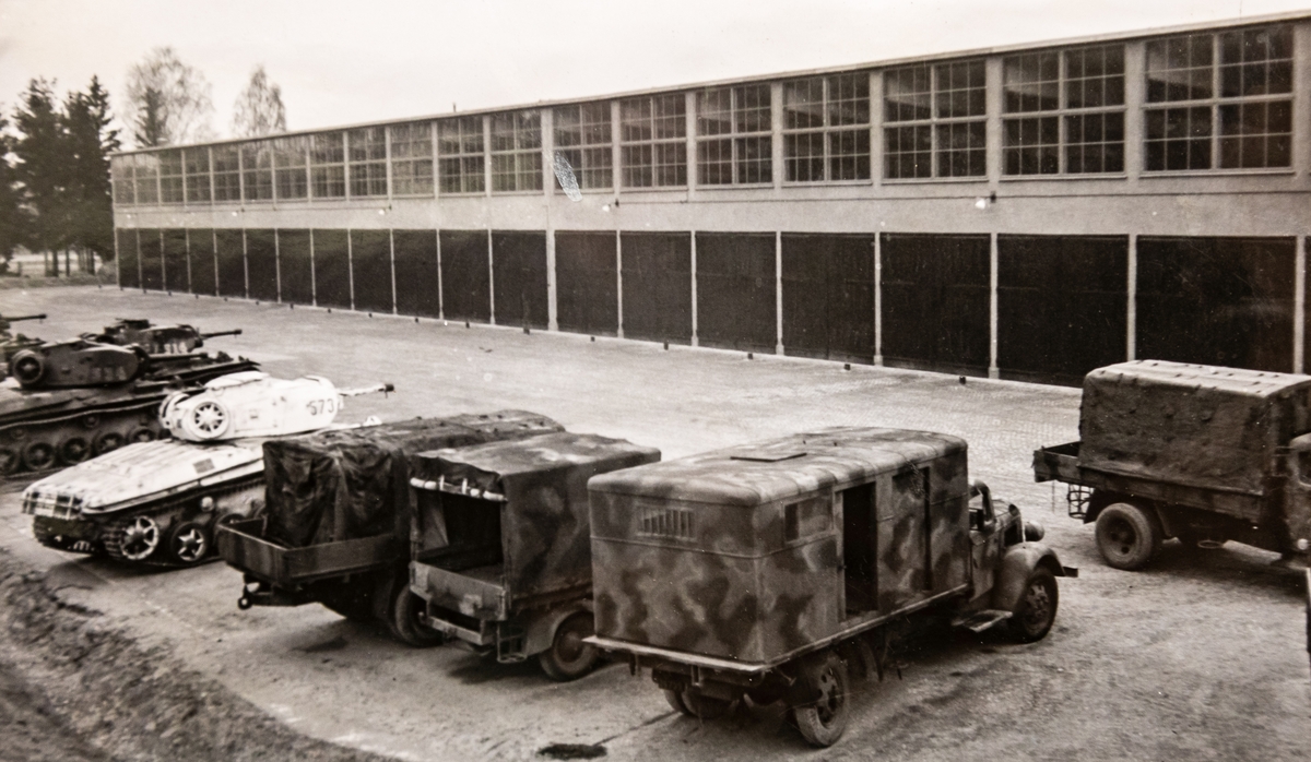 Tygverkstaden, byggnad 129, april 1945

Bild 1
Stridsvagnsverkstaden, där några stridsvagnar väntar på att köra in.

Bild 2
Personalens cykelparkering. På gaveln var ingång till kontor och mäss.