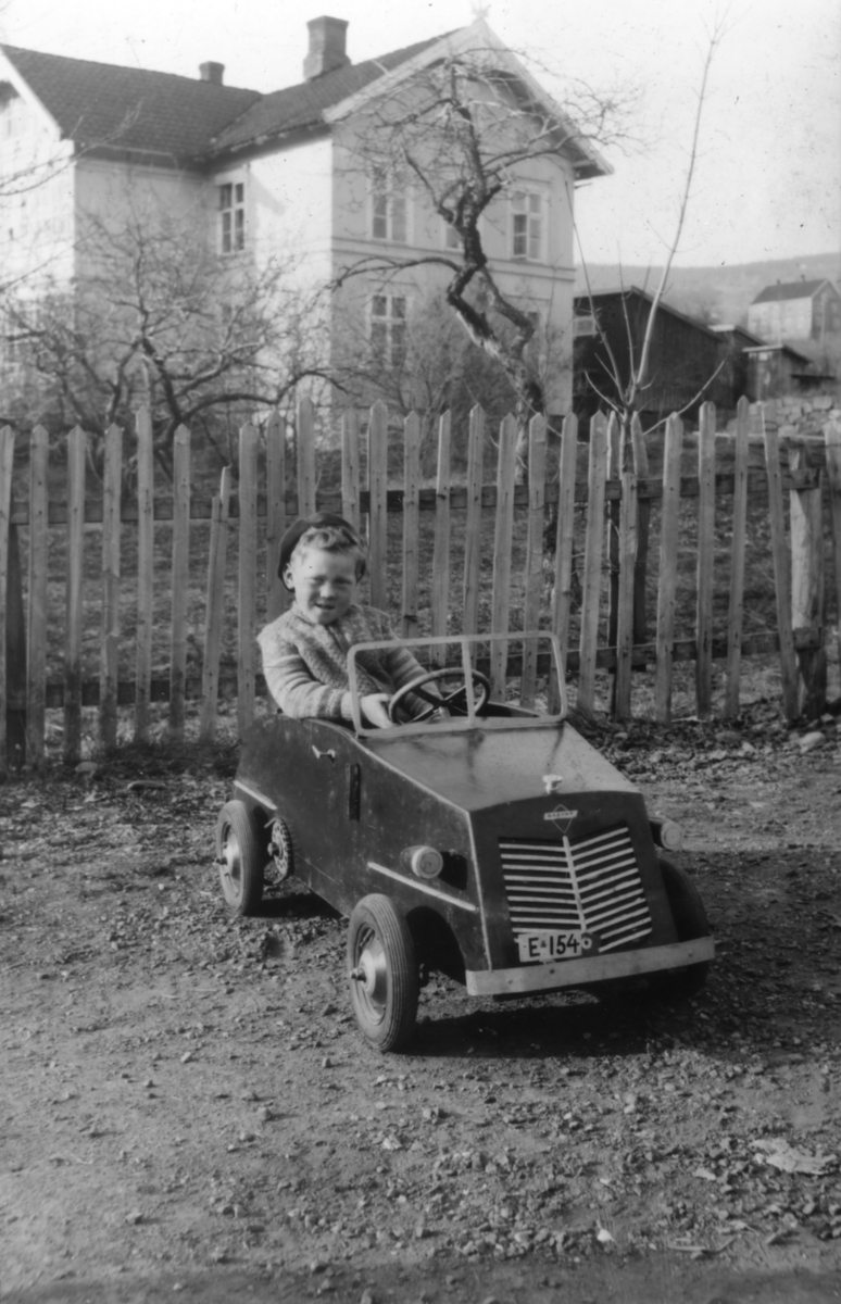 Gutt i tråbil, villa i bakgrunnen - Maihaugen / DigitaltMuseum