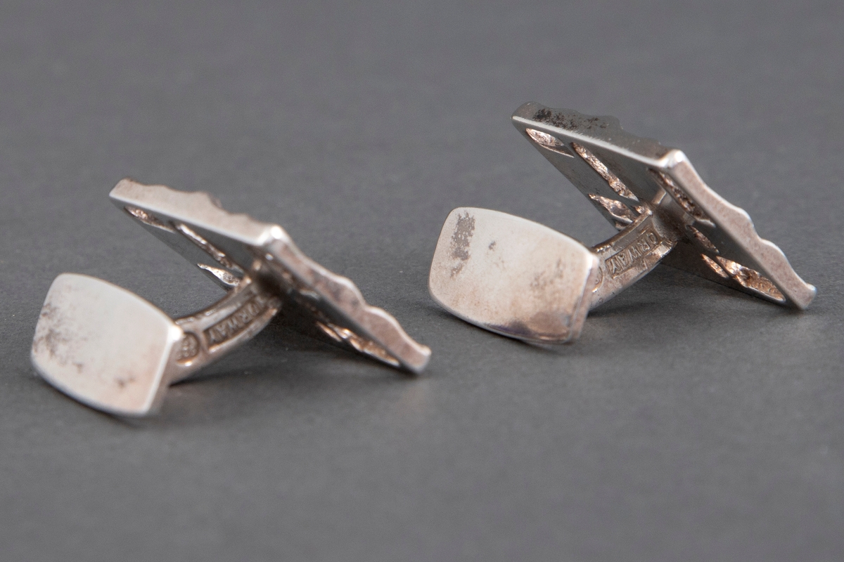 Et par mansjettknapper i hamret sølv med emalje i blånyanser.