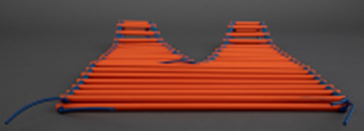 Halssmykke i rektangulær form med rombeformet åpning, som gir V-ringning foran og bak. Smykket består av oransje plastrør som er tredd på tvers på tynne, blå plastledninger. Det er små biter av blå plastrør mellom de oransje. Plastledningene er knyttet i endene. Smykket henges over skuldrene.