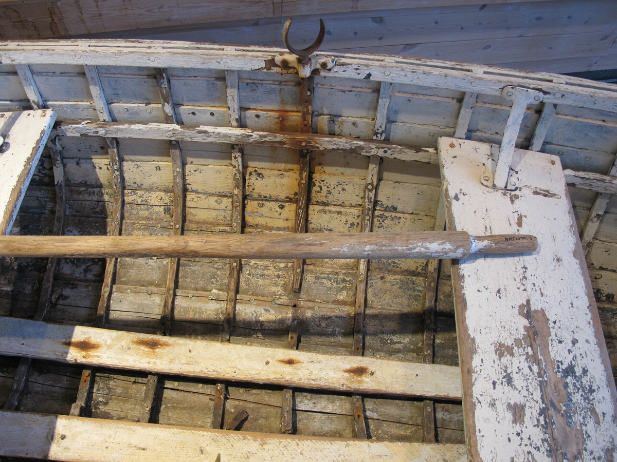 Gaffelformet åregaffel i jern med to tenner. Den er plassert oppi en gaffelholder festet til båten.