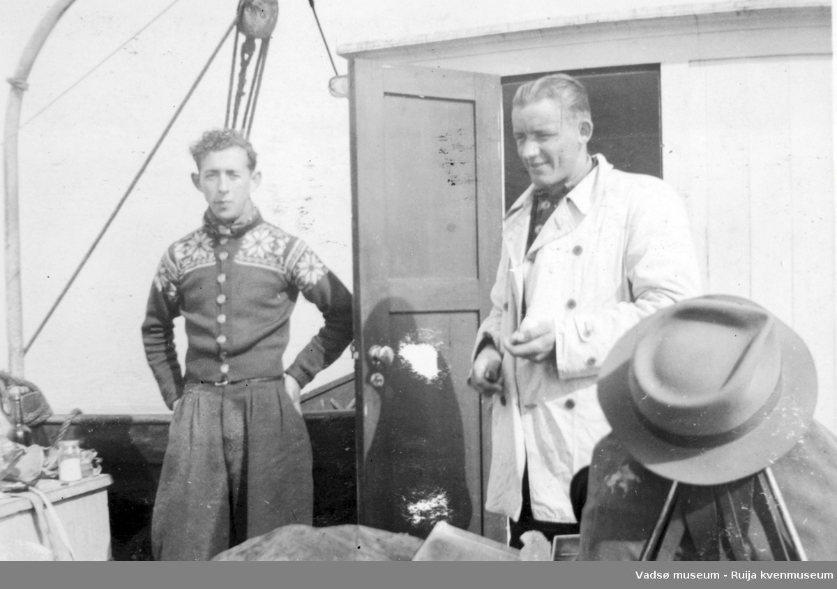 To menn ombord i båt, ant. skøyte. Under transport fra Tromsø til Vadsø, 1943.