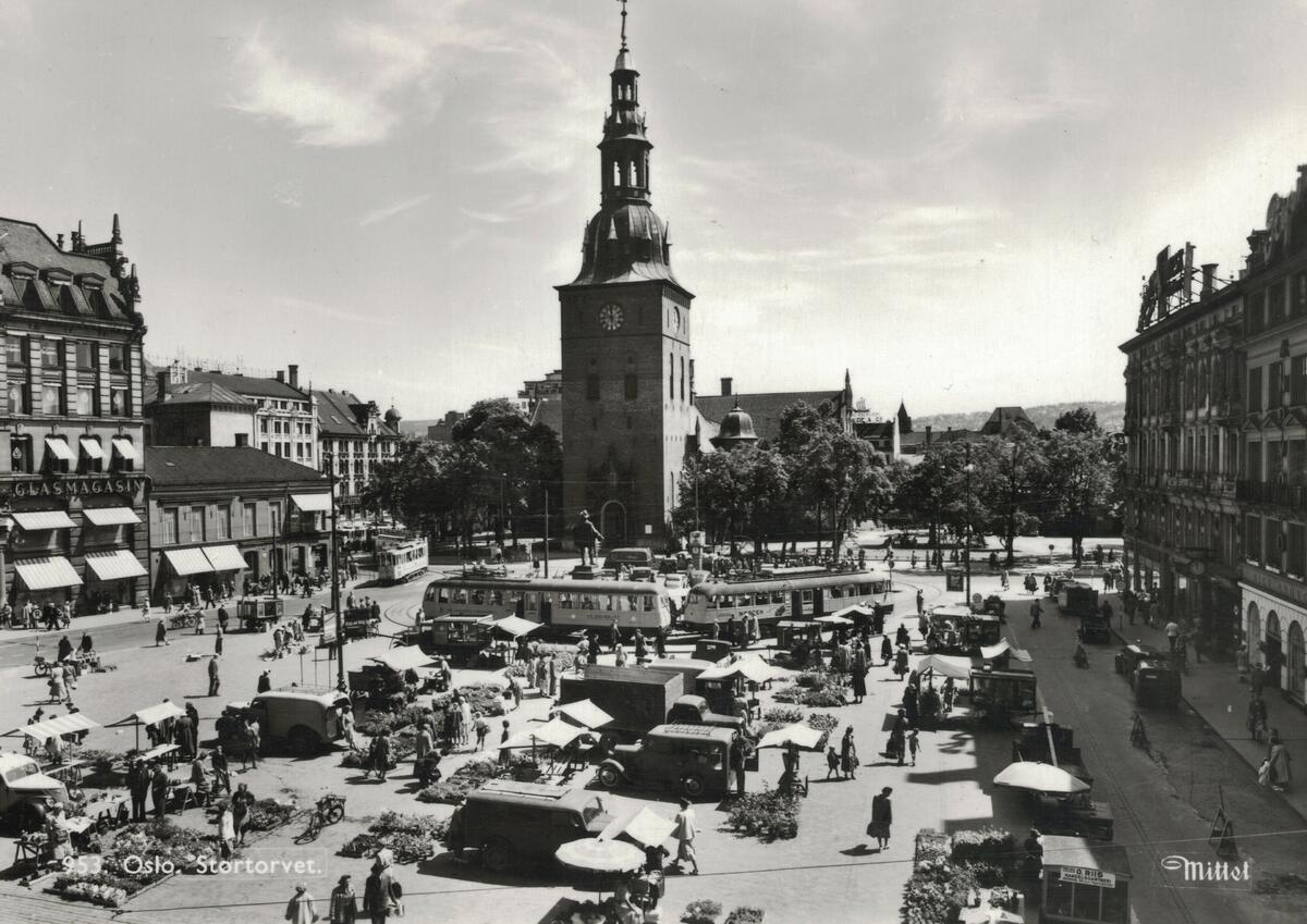 Stortorvet fotografert i 1955. I tillegg til mange mennesker og biler kan man se Ekebergbanen, nr. 1042 og 1023 i sløyfa.