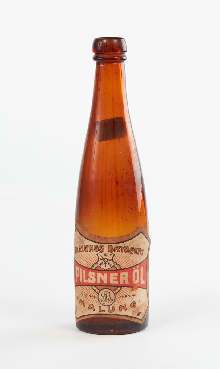 Fyra glasflaskor, 3 bruna, 1 grönblå. Etiketter: Malungs Bryggeri, Pilsner Öl, Original Tappning, Malung".
Något skadade i mynningskanterna.