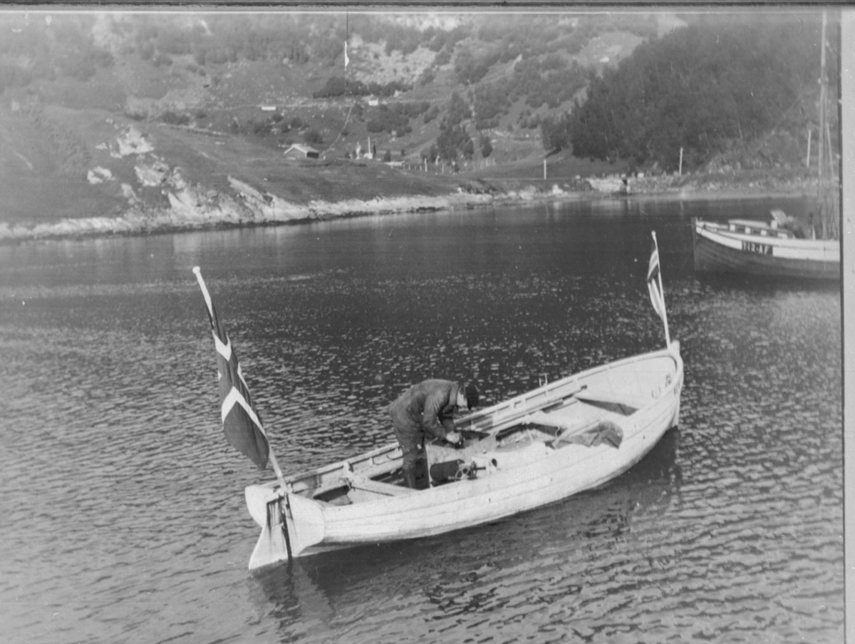 Mann arbeider med motoren i en lystbåt i Grovfjord.