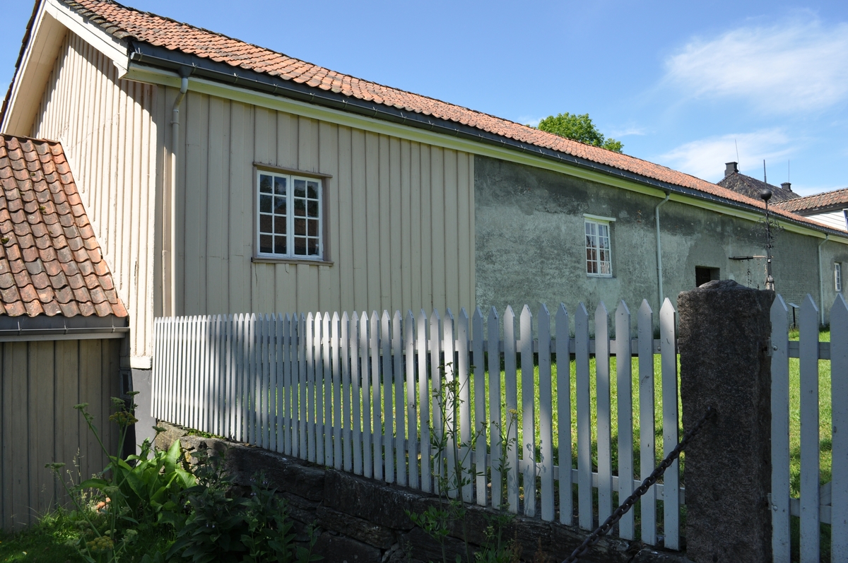 Uthusfløy til Søndre Brekke gård, oppført samtidig med de andre fløyene (nord, sør og øst) 1811-13. Dels oppført i tre, dels i natursteinsmur. Inneholdt fjøs og staller.