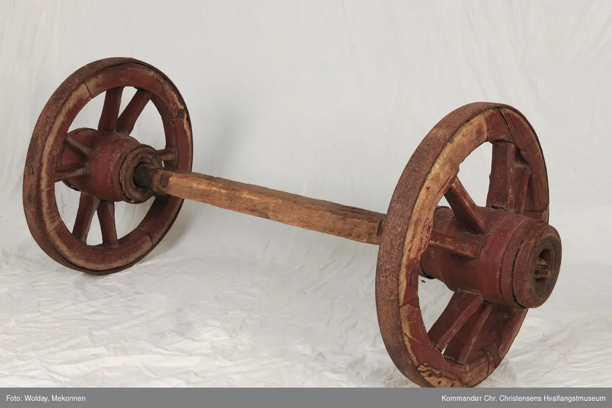 Aksling, teljet med jernbeslag. 
Hjul med 8 eiker parvis diagonalt plassert, jern- skodd jernbeslag på navet med treaksling (3 deler) 
