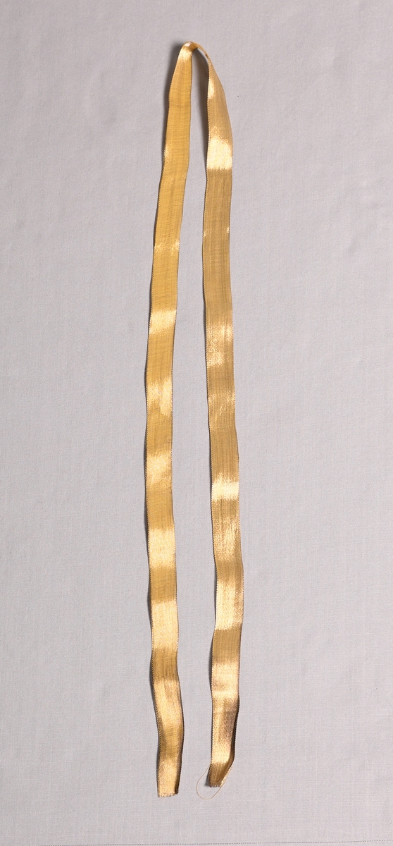 Knytskärp av guldlaméband.