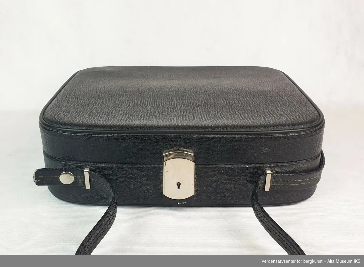Grå reiseskrivemaskin i låsbar sort koffert med stropper.