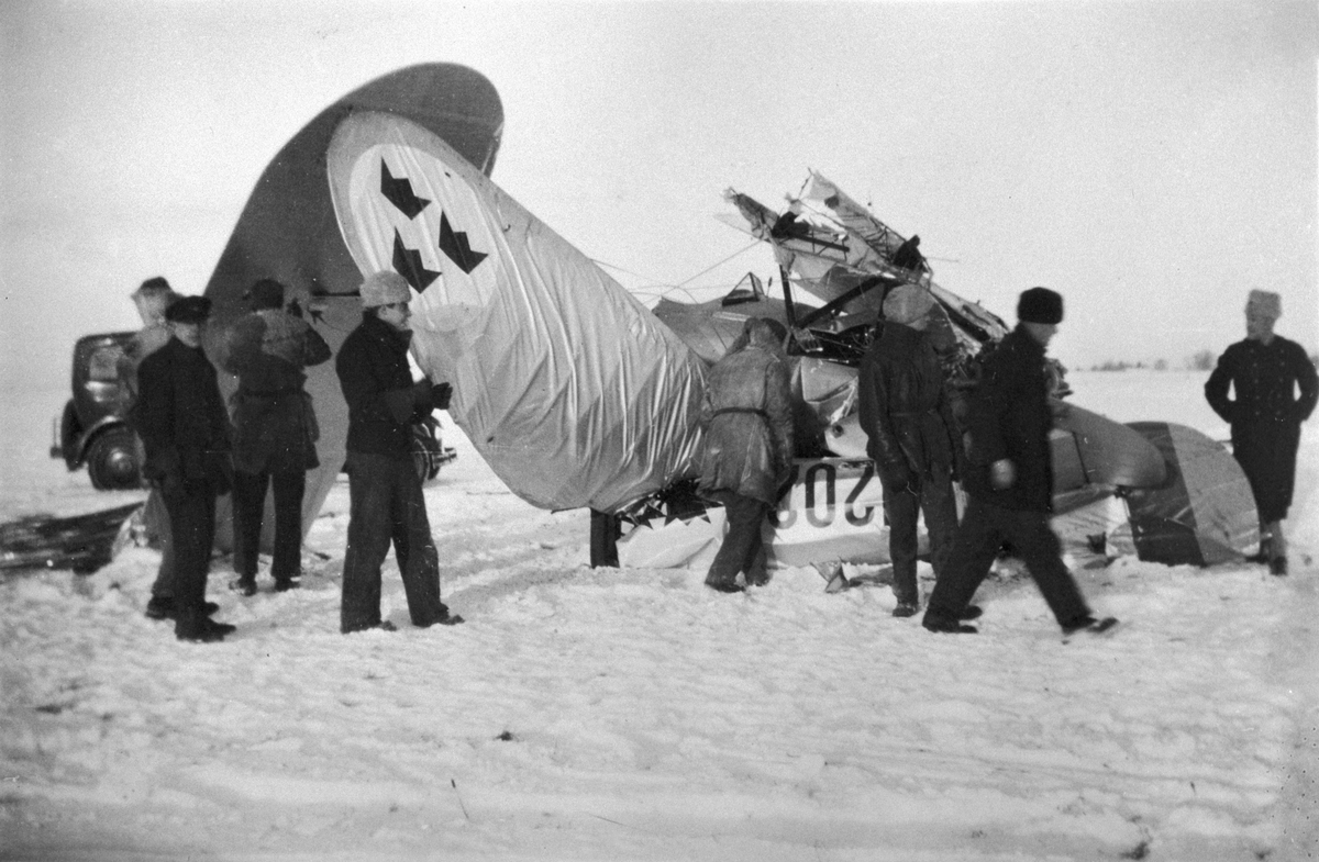 Landningshaveri med flygplan J 7, Bristol Bulldog, nr 1202 på F 3 Malmslätt, 20 januari 1931. Folksamling vid flygplanet. Skidorna fälldes nedåt vid landning. Flygförare Magnus Bång skadades lätt.
