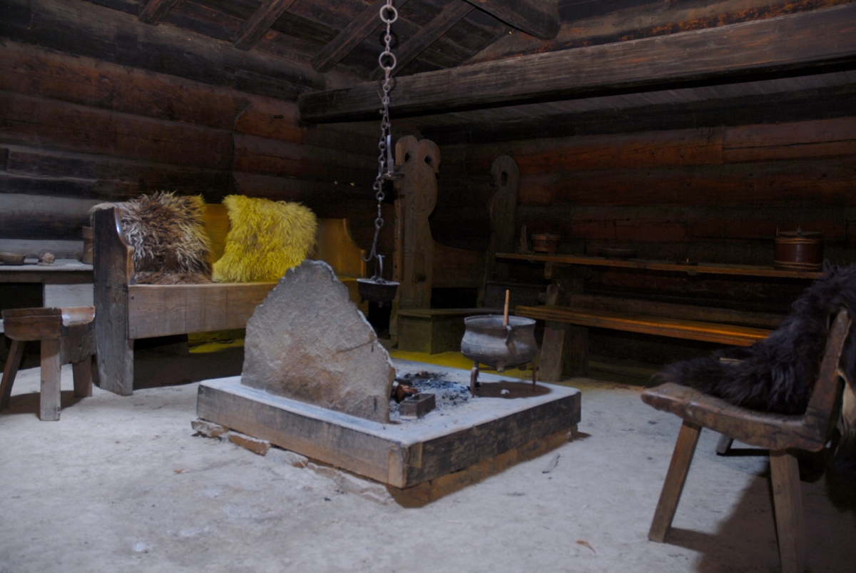 BRUSTOGA
Frå Åbø-Groven, seinare Bru, i Vinje.  Brustoga er ei årestoge frå mellomalderen. Den har ope eldstad (åre) midt på golvet og røykopning (ljore) i taket, der røyken kan sleppe ut og ljoset inn. Golvet er av hardtrampa jord. Årestoga var den vanlege stogetypen gjennom heile mellomalderen, og i fjellbygdene i Telemark var dei i bruk til langt inn på 1700-talet, da stoger med peis og skorstein vann innpass. 

Stoga har magetelgd tømmer av malmfuru i veggene. Svalgangen ber årstalet 1704. På beitskiene ved døra er det innrissa solhjul, valknute og livets tre. Husbondseng inne i stoga har ein hest skore inn i den eine stolpen. I veggen over senga og ved sida av inngangsdøra er det kikkehol så det var mogleg å sjå ut. Årestogene hadde ikkje vindauge. Brustoga representerer, sammen med Sollidloftet og Bekkhusburet, byggjeskikken i Vest-Telemark ved museet. 

Brustoga hadde mange spor av årestoge ved innkomsten til museet, bl.a. ljoregrima, bitane (tverrbjelkene) inne, klampen for gjelgja og beitskier. Den blei rekonstruera som årestoge ved gjenoppføring på museet.


THE BRU COTTAGE
From Åbø-Groven, later Bru, in Vinje

The Bru cottage is an open-hearth cottage from the Middle Ages. It has an open hearth in the middle of the floor, and a smoke vent in the roof, where the smoke can escape and the light can enter. The floor consists of hard-trampled earth. The open-hearth cottage was the most common type of cottage throughout the Middle Ages. These were in use in the villages in the mountains of Telemark well into the 18th century, when cottages with fireplaces and chimneys came into use.

The cottage has logs of pine, rich in heartwood, in the walls. The hallway has the date 1704 on it. Sun wheels are carved in the end supports for the logs by the door, and on the wall beside the entrance door there is a peep hole to make it possible to look out. Open-hearth cottages did not have windows.

Along with the Sollid loft and the Bekkhus-buret, the Bru cottage represents building traditions in West-Telemark at the museum.