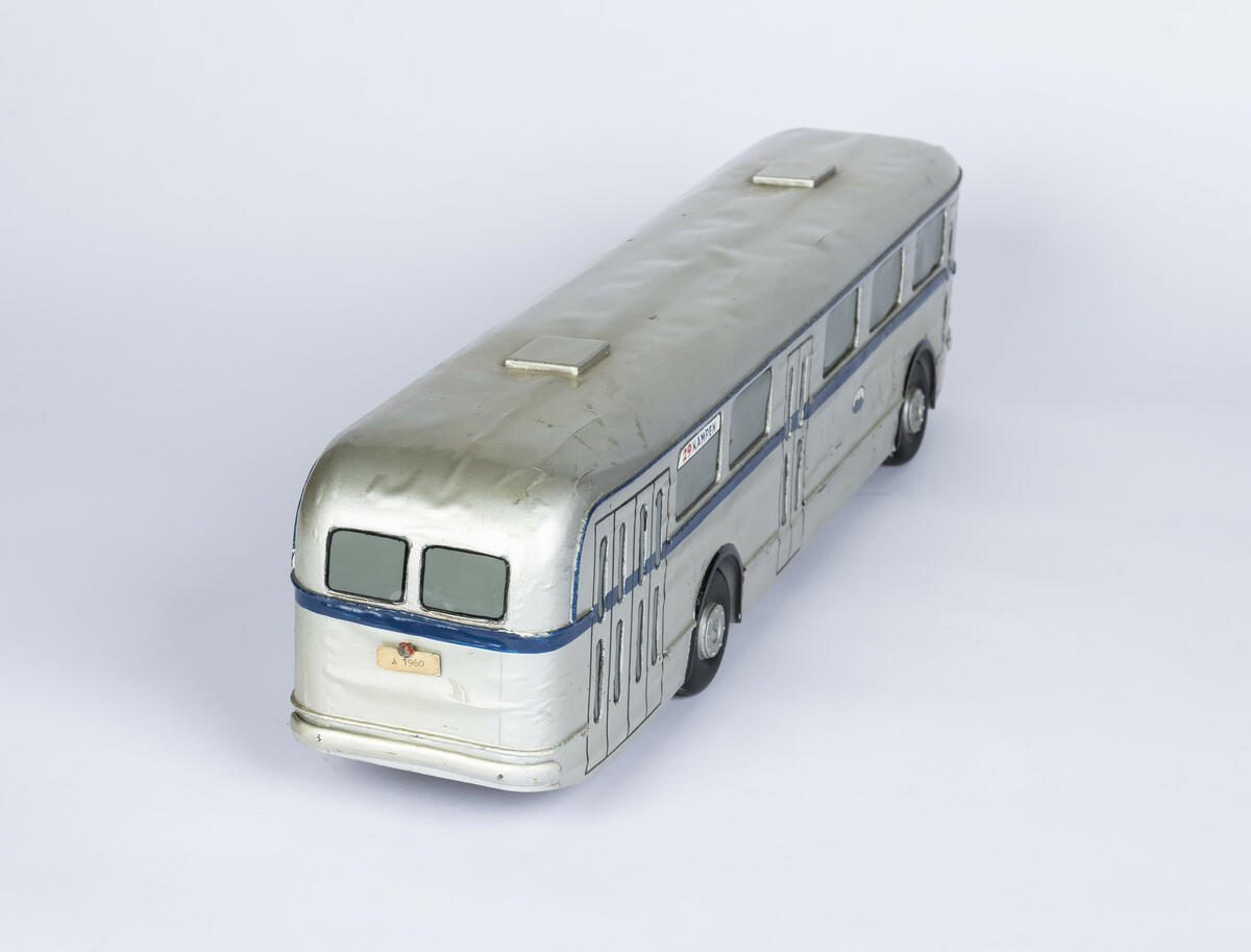 Tremodell av sølvfarget buss med mørk blå stripe som går rundt hele bussen på midten. Over frontruten står nummeret 29 og destinasjon, som er Kampen. 