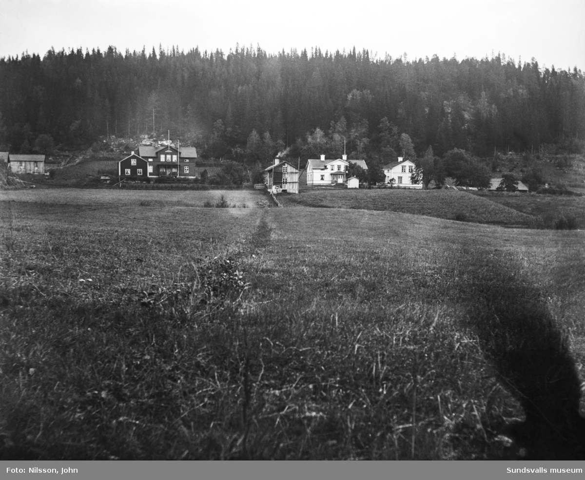 Vy mot två gårdar i Roken, Laggarberg, Timrå. Den ljusa gården till höger var fotografen John Nilssons hem.