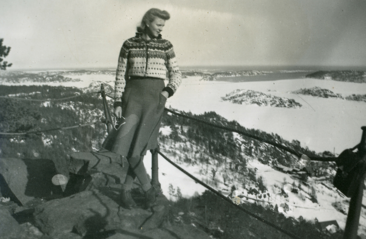 Kvinne oppe på ein fjelltopp med utsikt over havet.  Kvanna har førenamnet Anne-Synnøve.  Tatt påska 1940.