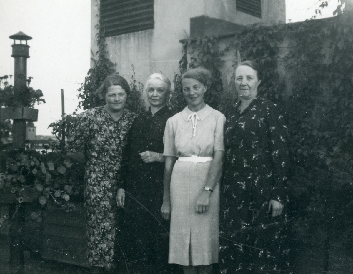 Portrettfoto av fire kvinner utanfor eit hus.