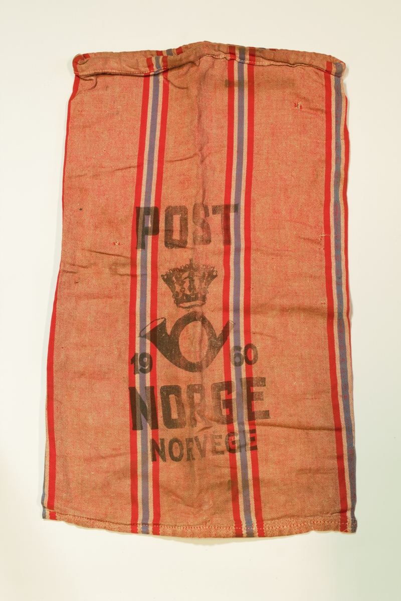 Postsekk vevd i toskaft med naturfarget og rød tråd. Vertikale striper med fargene til det norske flagget i rødt, hvitt og blått. Postens logo er trykket i svart på forsiden.