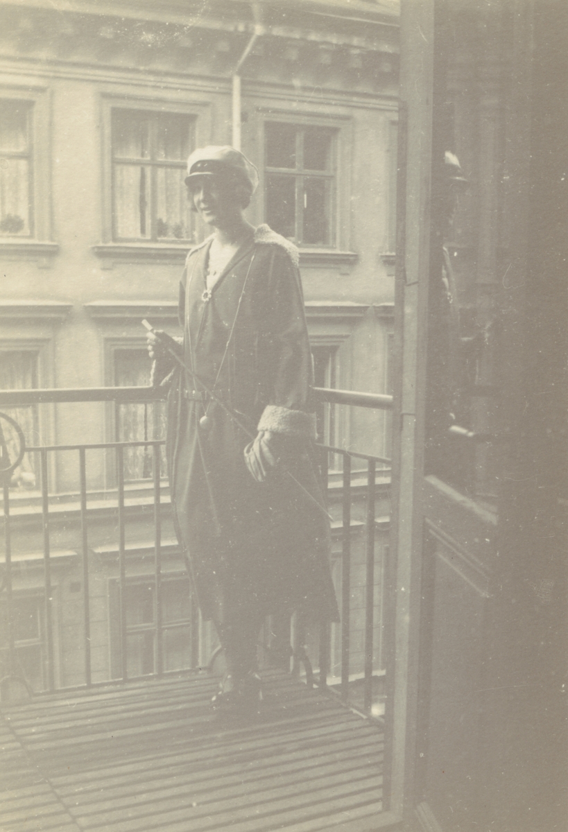 Fotografi från Albin Ahrenbergs resa till Grönland 1929. Motiv av kvinna på balkong i stad.